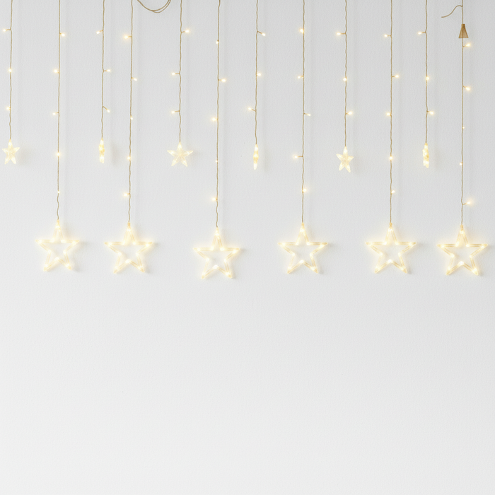 Catena luminosa a stelle con luci LED calde su sfondo bianco per decorazioni di Natale e camera da letto